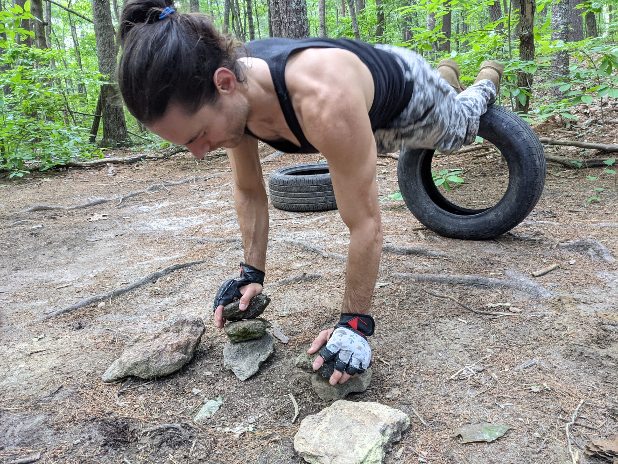 Outdoor strength training on rocks and a tire